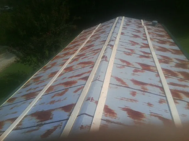 Rusted metal roof panels with new wood purlins before replacement — Storm Damage Roof Repair in Melville by Roofing Brothers